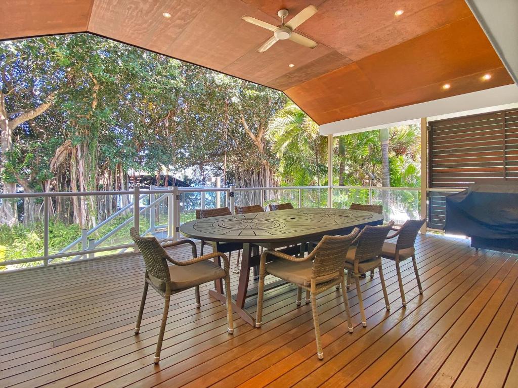 una mesa de comedor y sillas en una terraza en Picnic Bay Apartments Unit 3, en Picnic Bay