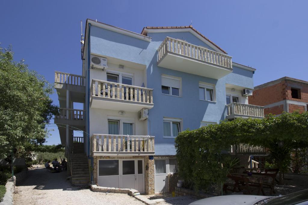 un edificio alto de color azul con balcones. en Apartments Crnjac, en Rogoznica