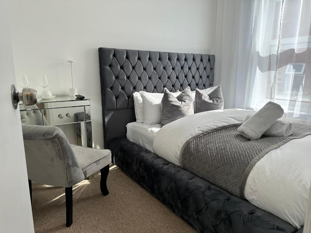 um quarto com uma cama grande e uma cadeira em The smaller new refurbished room 5 min from beach/parking in Guests house. em Bournemouth