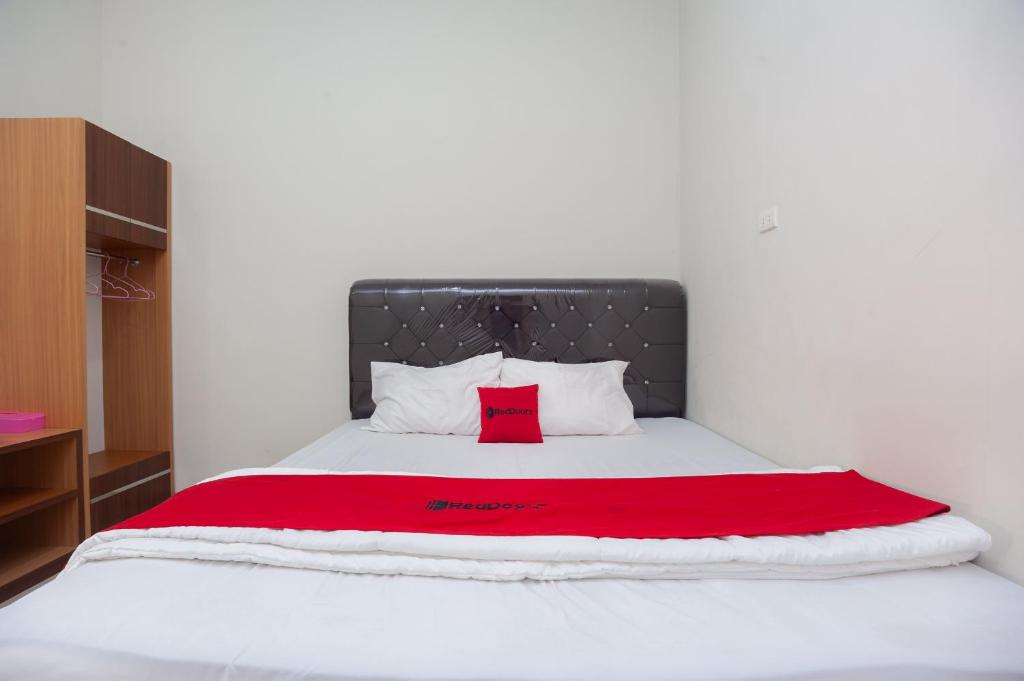 ein Schlafzimmer mit einem großen Bett mit einer roten Decke in der Unterkunft RedDoorz @ Jalan Urip Sumoharjo Lampung 2 in Lampung