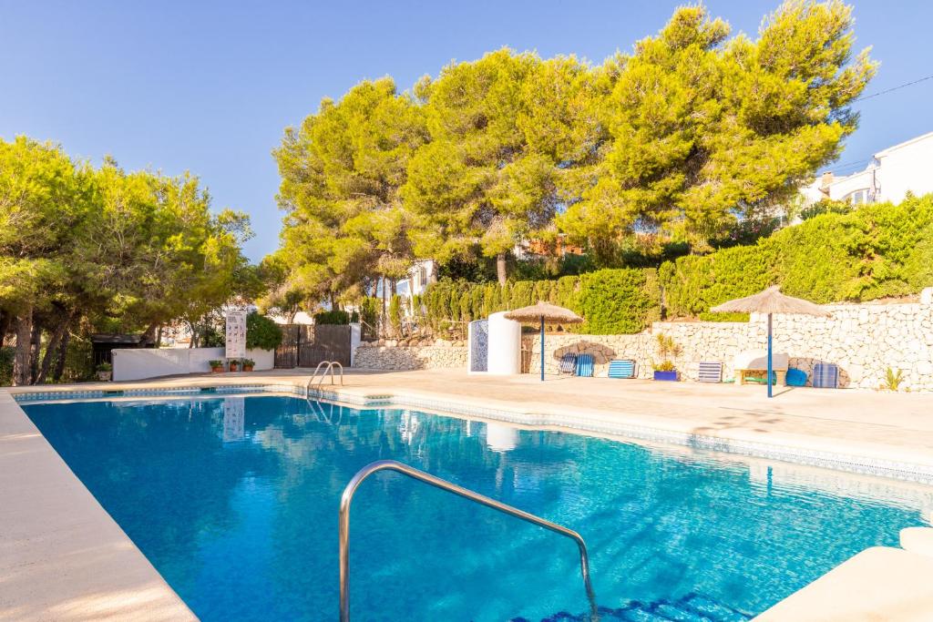 una piscina en una villa con árboles en Cap d'or house en Moraira