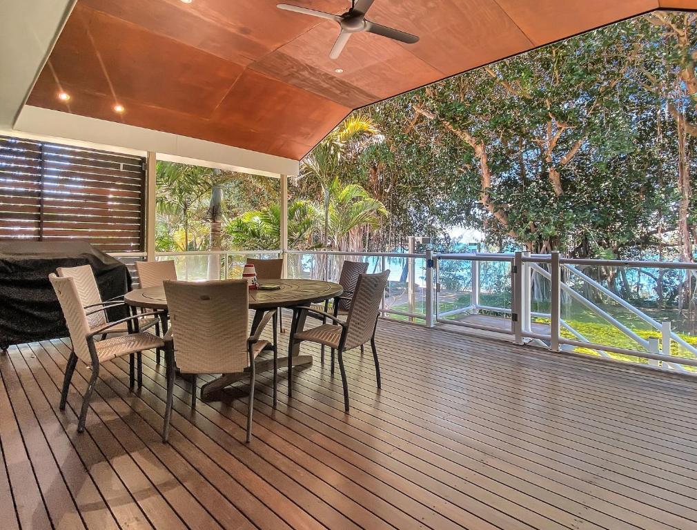 une salle à manger avec une table et des chaises sur une terrasse dans l'établissement Picnic Bay Apartments Unit 4, à Picnic Bay