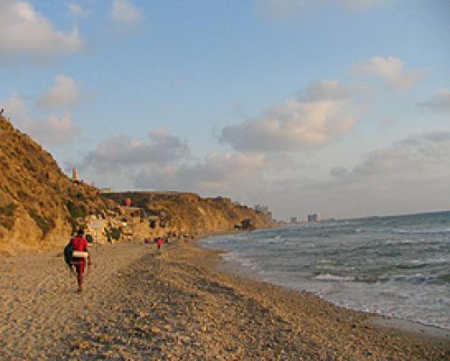 eine Person, die am Strand in der Nähe des Ozeans läuft in der Unterkunft Cozy 2-bedrooms with balcony 20 in Bat Yam