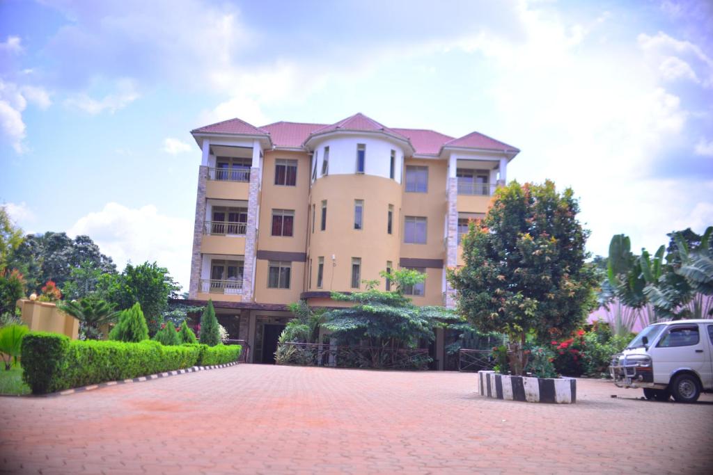 ein großes Gebäude mit einem davor geparkt in der Unterkunft Elgon Palace Hotel - Mbale in Mbale
