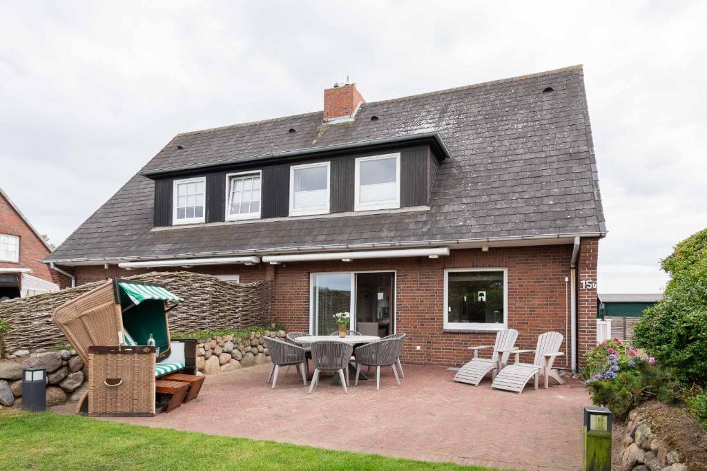 una casa con patio arredato con tavolo e sedie di Dacklünen a Wenningstedt