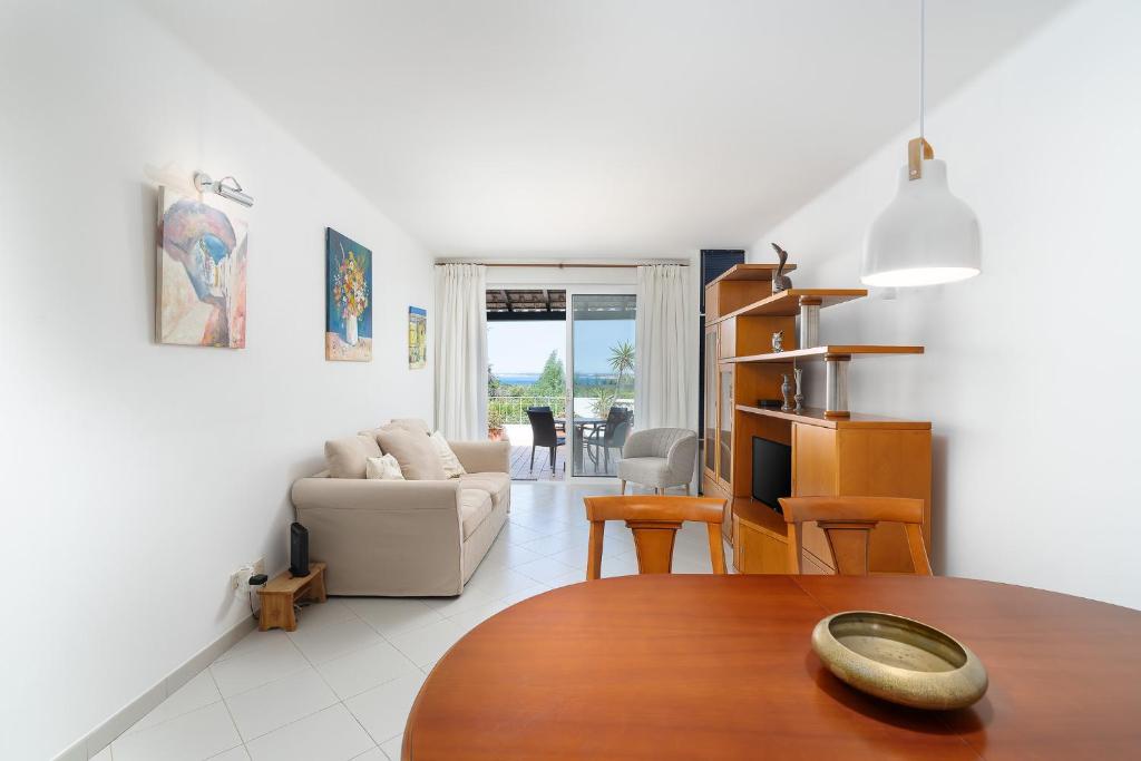 una sala de estar con una mesa y un sofá en Vila Gaivota 1C, en Ferragudo