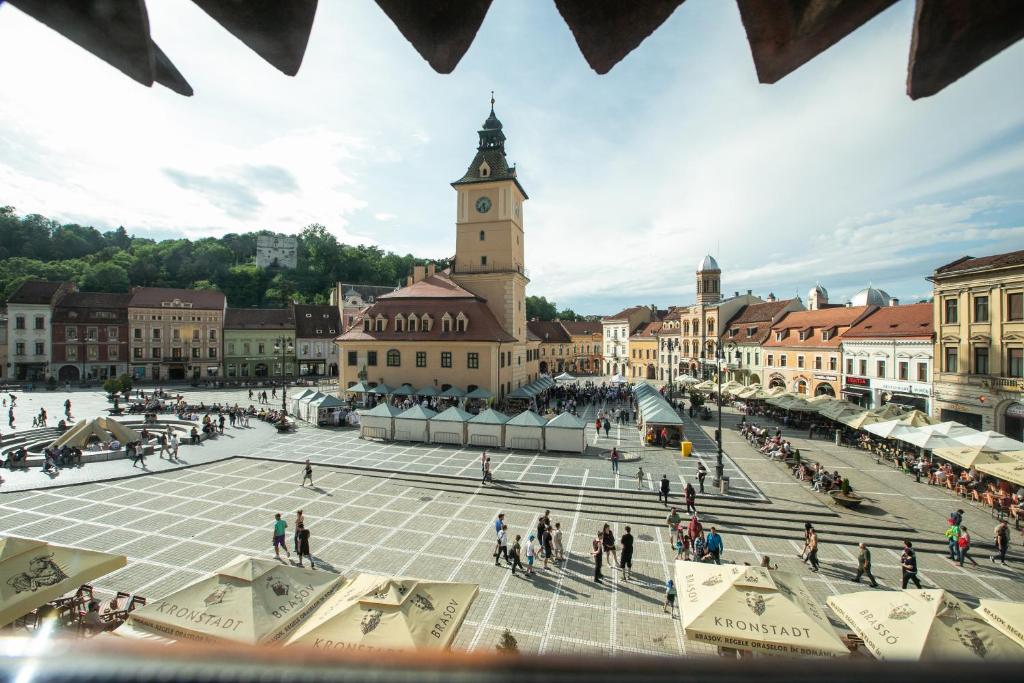 vista su una piazza della città con torre dell'orologio di 4 Rooms Piata Sfatului a Braşov