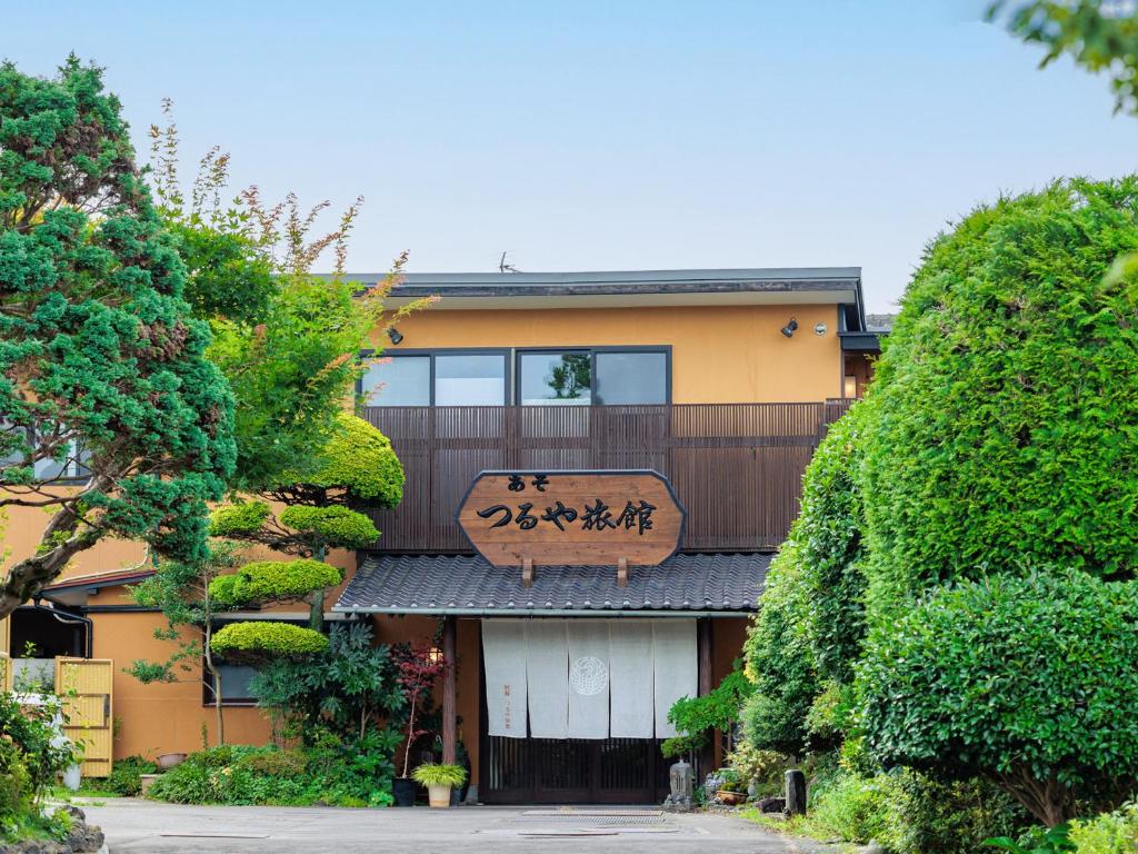 a building with a sign on the front of it at AsoTsuruya in Aso