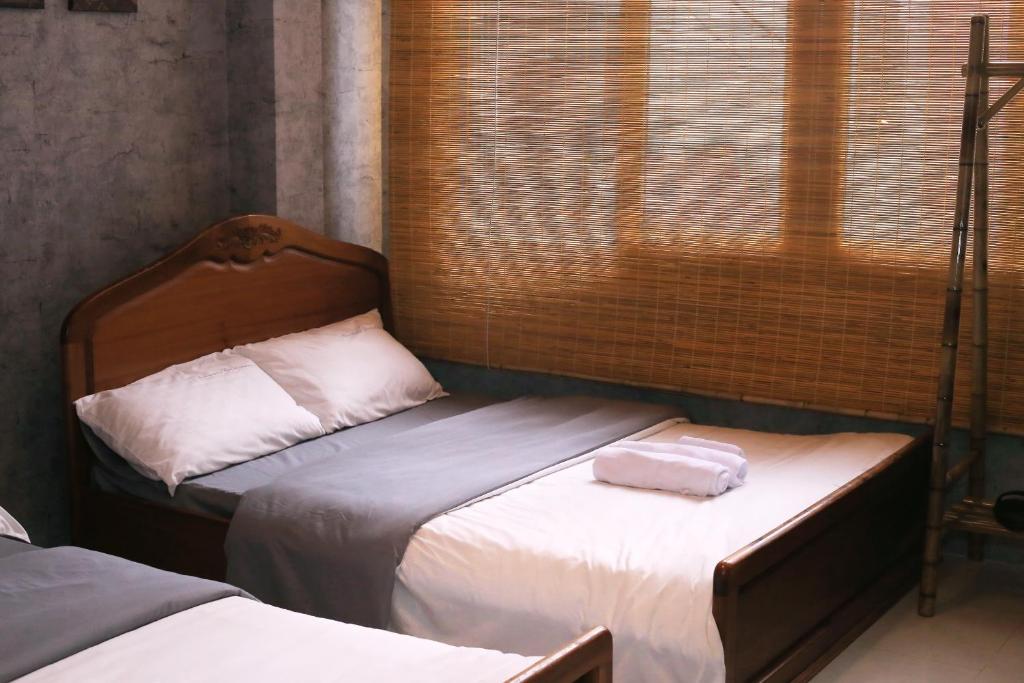 sypialnia z 2 łóżkami i oknem w obiekcie Nhà Quê Homestay w mieście Nha Trang