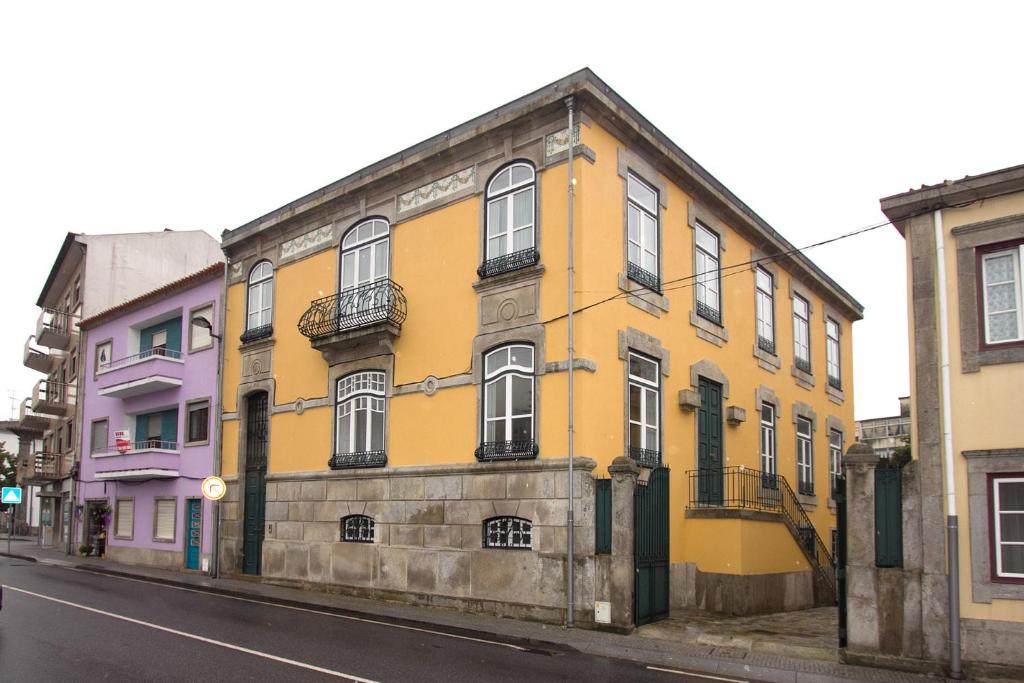 un edificio amarillo al lado de una calle en A Vianesa - Guest House, en Viana do Castelo