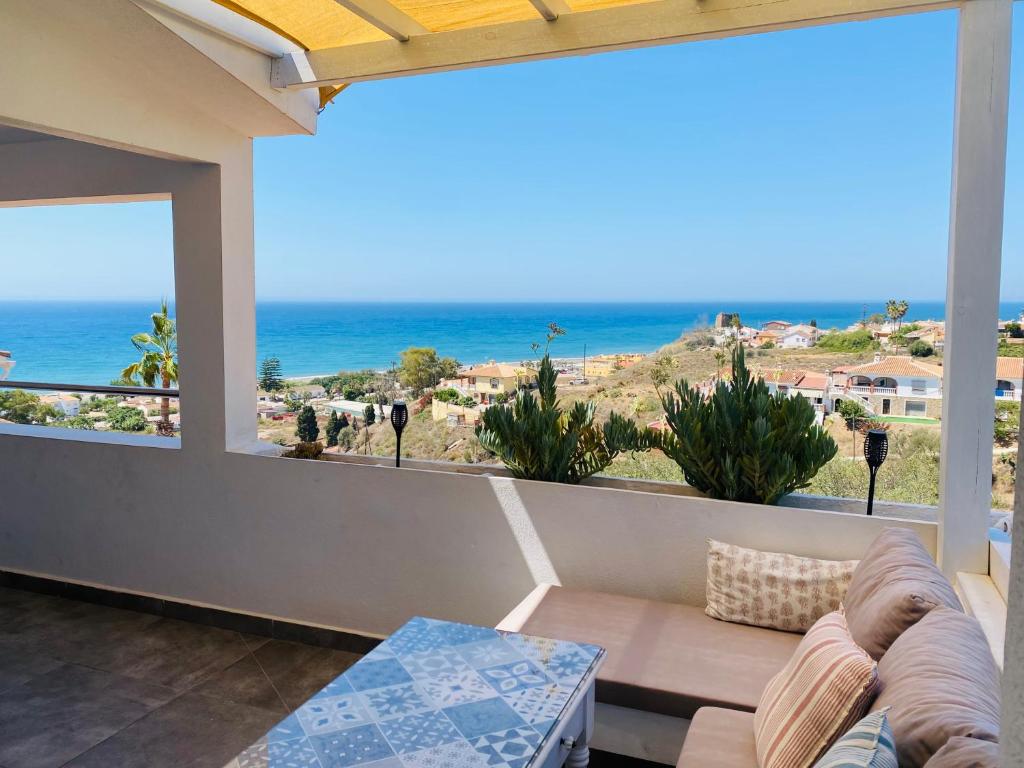 een balkon met een bank en uitzicht op de oceaan bij La Casita en Benajarafe in Málaga