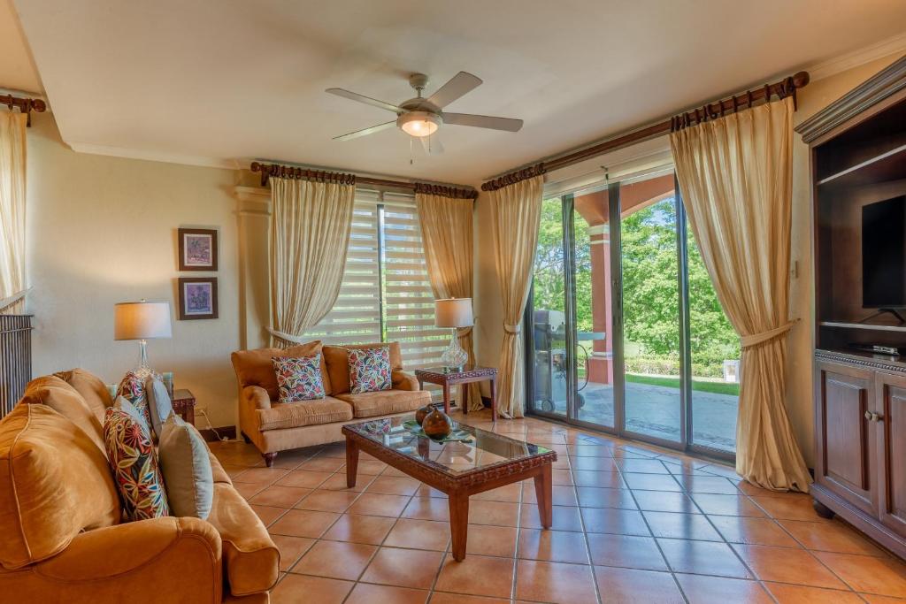 sala de estar con sofá y mesa en Bougainvillea 5102 Luxury Apartment - Reserva Conchal, en Playa Conchal