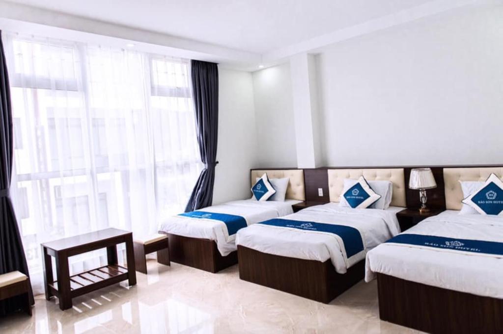 a hotel room with two beds and a window at Bảo Sơn Hotel in Ha Long