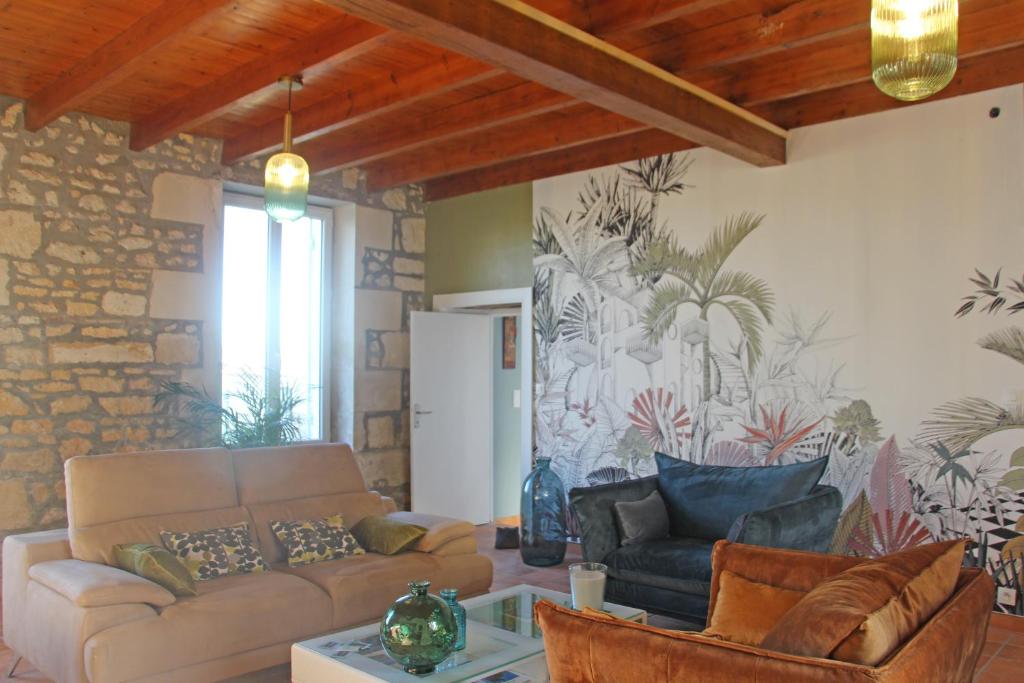 ein Wohnzimmer mit einem Sofa und einem Tisch in der Unterkunft Domaine de KIBA - Maison de Maitre in Barzan