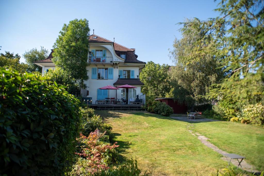 une grande maison blanche avec une cour dans l'établissement artroom, à Berne