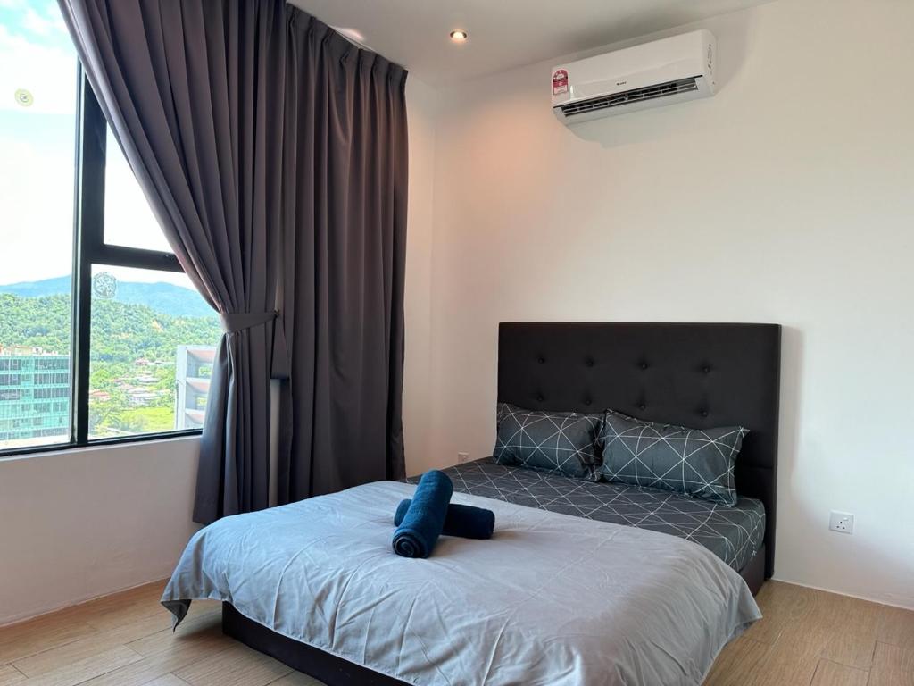 um quarto com uma cama com uma almofada azul em ITCC Manhattan Suites by Stay In 3pax em Donggongon
