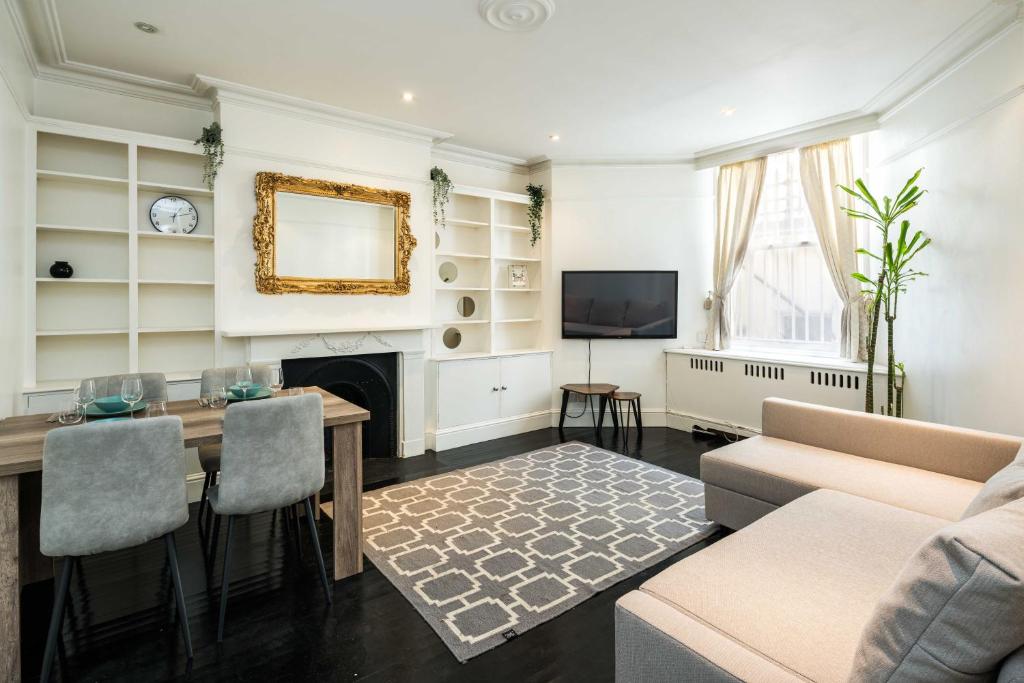 uma sala de estar com uma mesa e uma lareira em Spacious 1 bedroom / Gloucester Road / Harrods em Londres