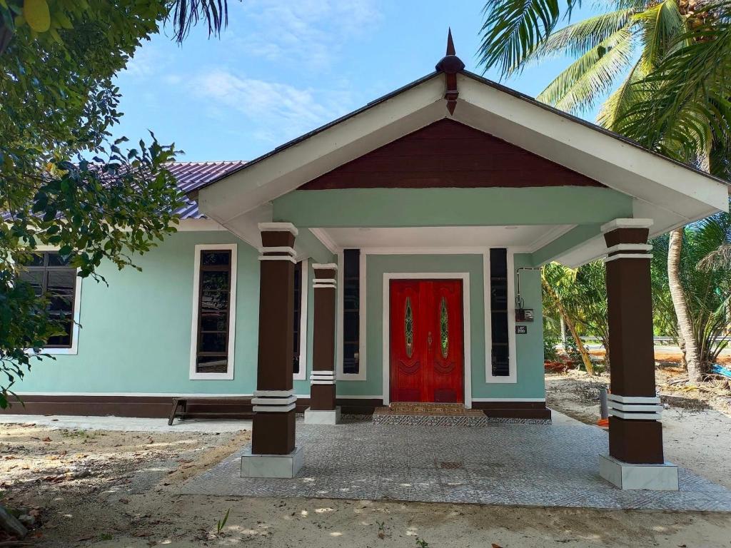 a small house with a red door at Inara Homestay Besut in Jertih
