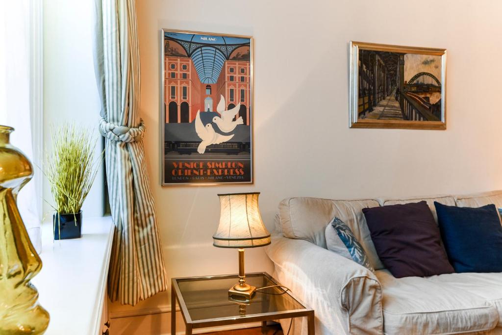 a living room with a couch and a table at HydePark Queens Gate Apt in London