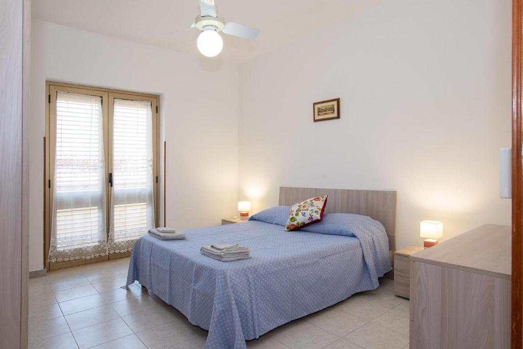 um quarto com uma cama azul e uma janela em Zion Mare em Soverato Superiore