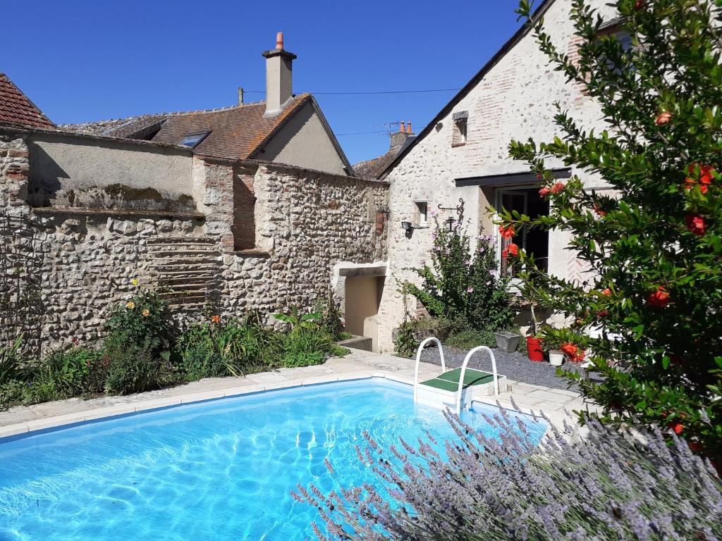 a swimming pool in a yard next to a building at La Chaumière in Ousson-sur-Loire