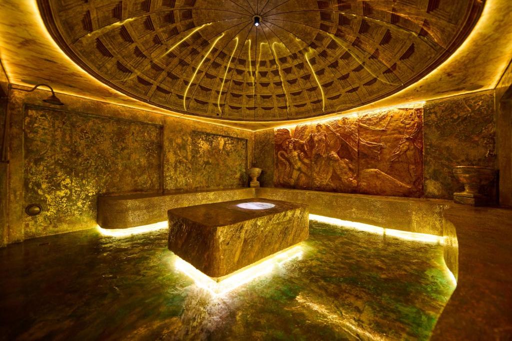 a room with a large ceiling and a table at Sianisia Adults Only & Private Spa in Haţeg