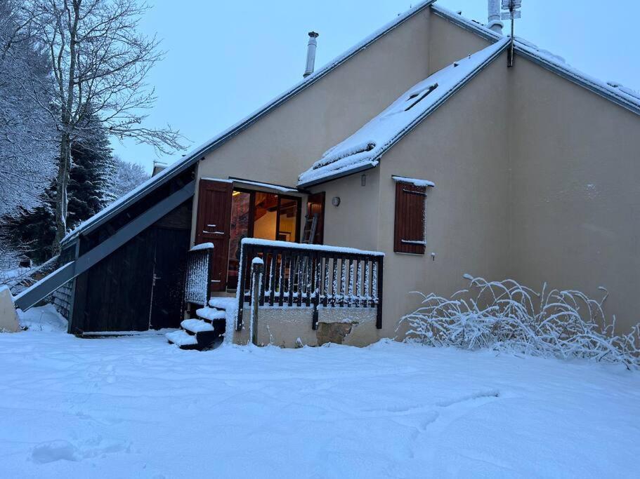 une maison avec de la neige au sol à côté d'un bâtiment dans l'établissement Chalet Laguiole Aubrac, à Laguiole