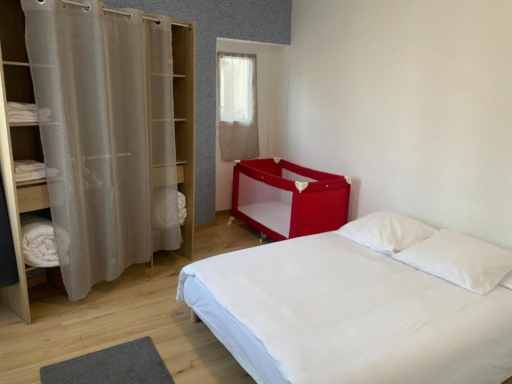 Un dormitorio con una cama blanca y una cómoda roja en Au cœur de Chessy, en Chessy