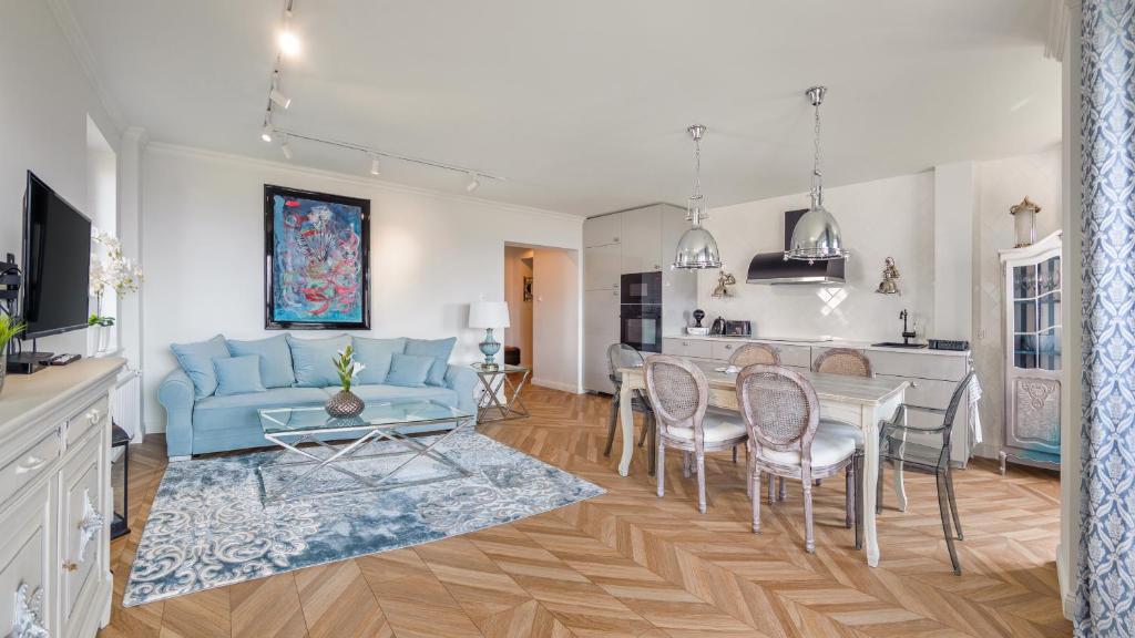 uma sala de estar com um sofá azul e uma mesa em Apartamenty Sun & Snow Hel Centrum em Hel