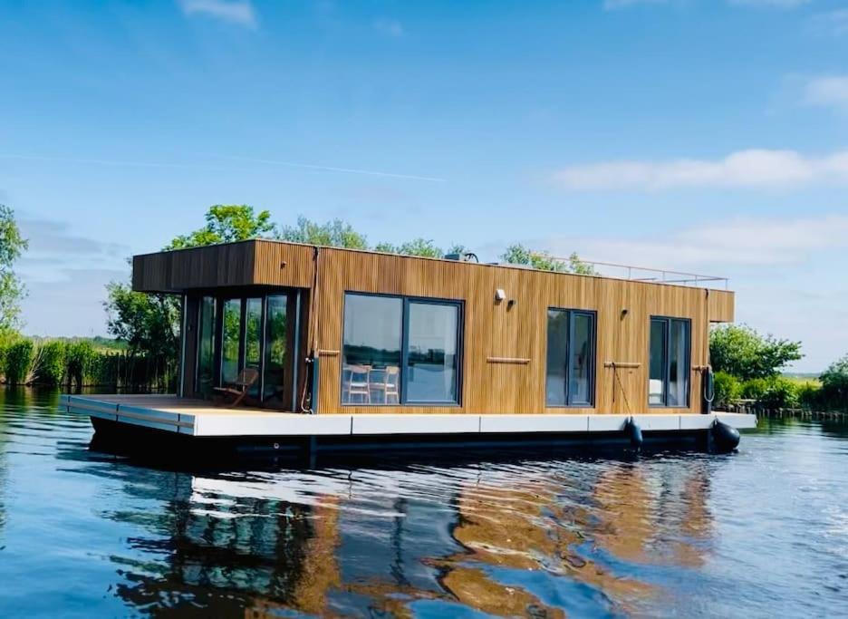 a tiny house on a floating dock on the water at Surla Houseboat De Saek with tender in Monnickendam