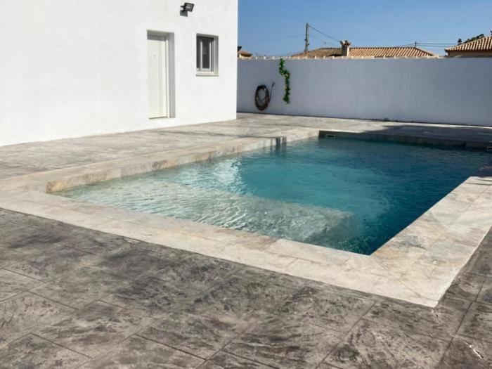 a swimming pool in the middle of a house at Villa El Lagar in Novo Sancti Petri