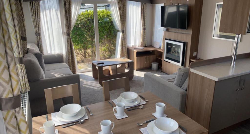 a living room with a couch and a table at 8 Berth Static Caravan - Holiday Resort Unity Brean in Berrow
