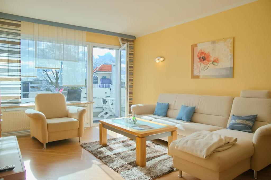 sala de estar con sofá, sillas y mesa en Haus Ostseeblick App 8 inkl WLAN, en Grömitz
