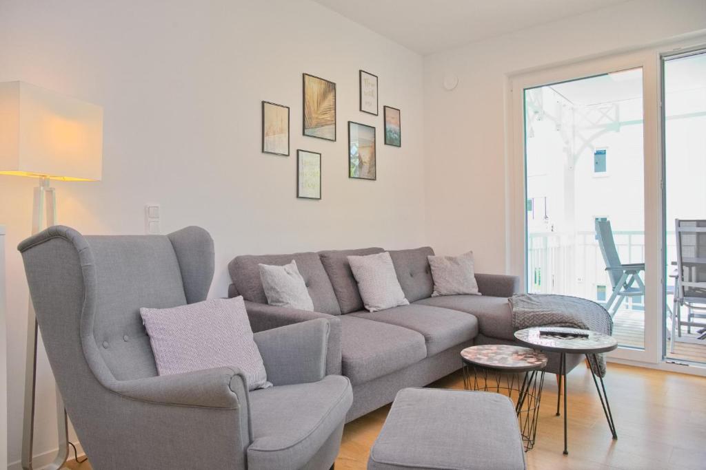 - un salon avec un canapé et une chaise dans l'établissement Weiße Villa Whg 5 inkl WLAN, à Grömitz