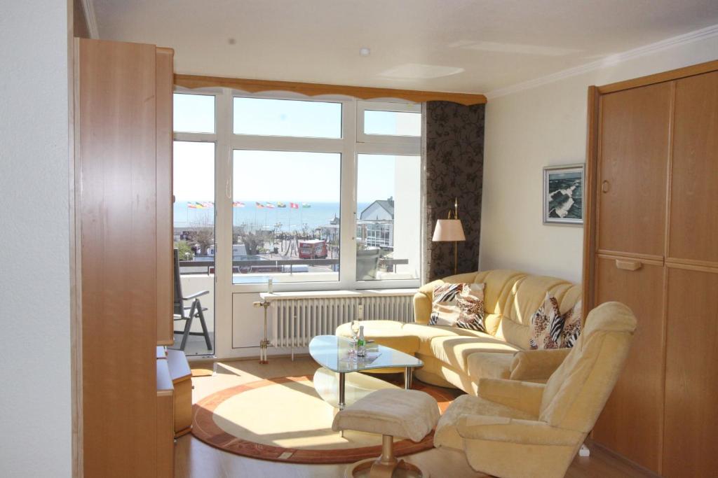 sala de estar con sofá, mesa y ventana en Villa am Meer App 81, en Grömitz