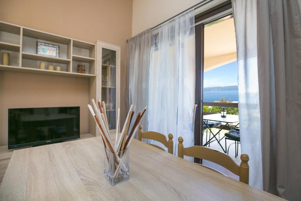 a dining room with a table and a television and a view at Apartment Gino in Ravni