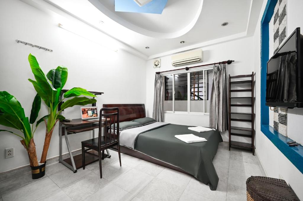 a bedroom with a bed and a table and a desk at Ohio Hotel & Apartment in Ho Chi Minh City