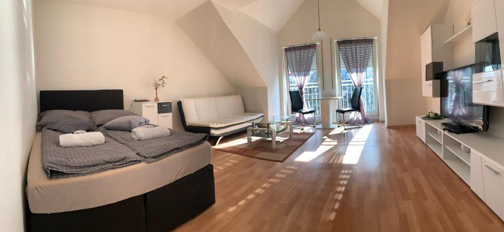 a bedroom with a large bed and a living room at ZV-Scholtz Burghausen, Mozartstr.15 AP-52 in Burghausen