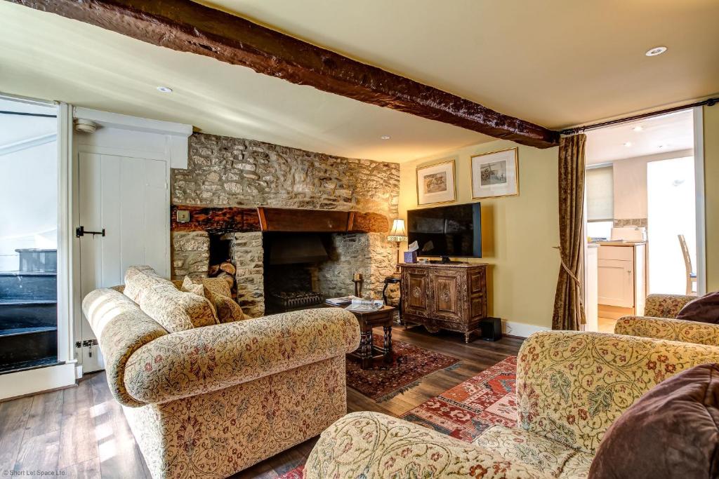 a living room with couches and a stone fireplace at Browns Lane in Woodstock