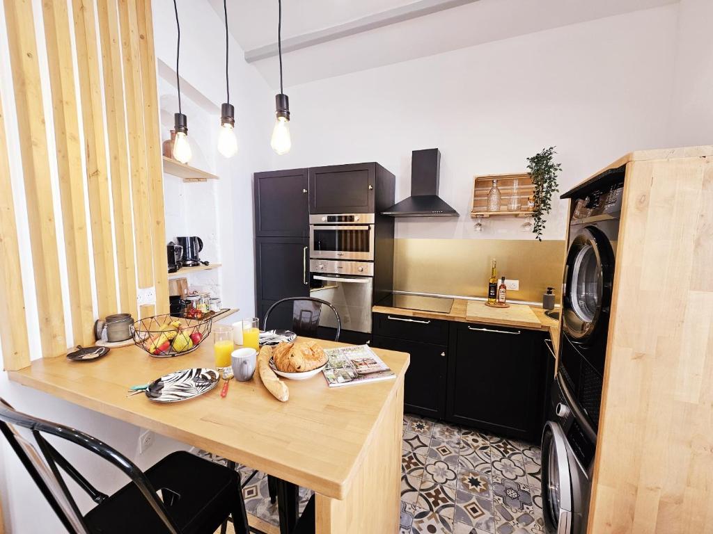 - une cuisine avec une table en bois dans une chambre dans l'établissement Le jardin vert, paisible maison de ville, à Angoulême