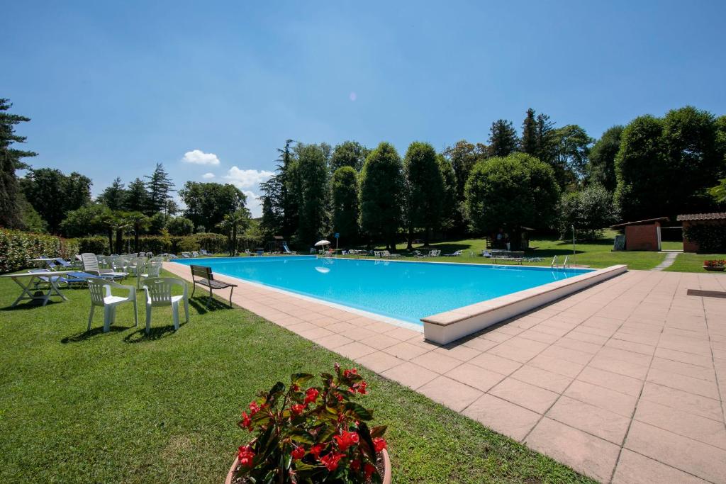 una piscina en un parque con sillas y flores en Casa Lavanda Pool, Tennis - Happy Rentals, en Ispra