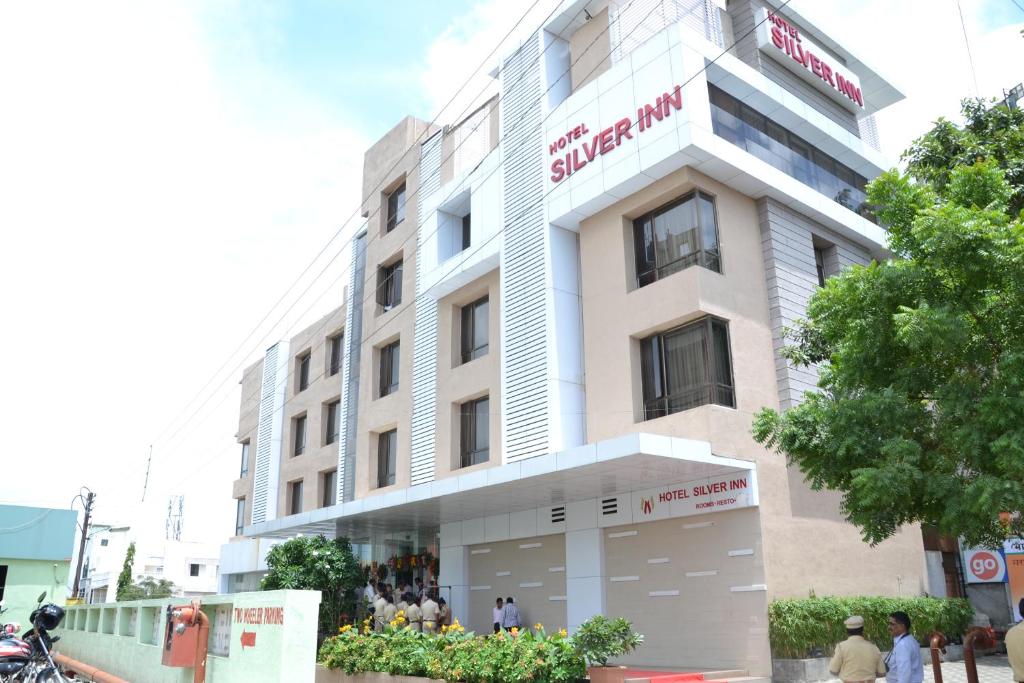 un gran edificio blanco con un cartel. en Hotel Executive Silver Inn, en Aurangabad