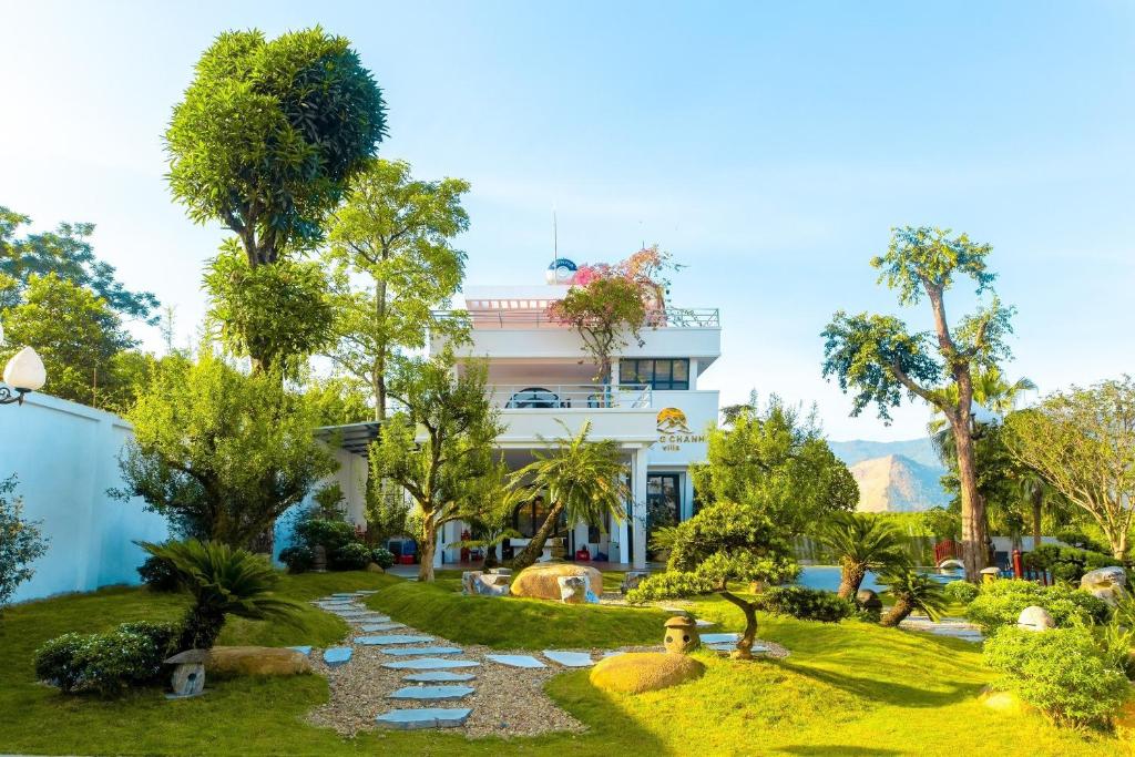 un jardín frente a un edificio blanco en Đồng Chanh Villa Venuestay, en Hòa Bình