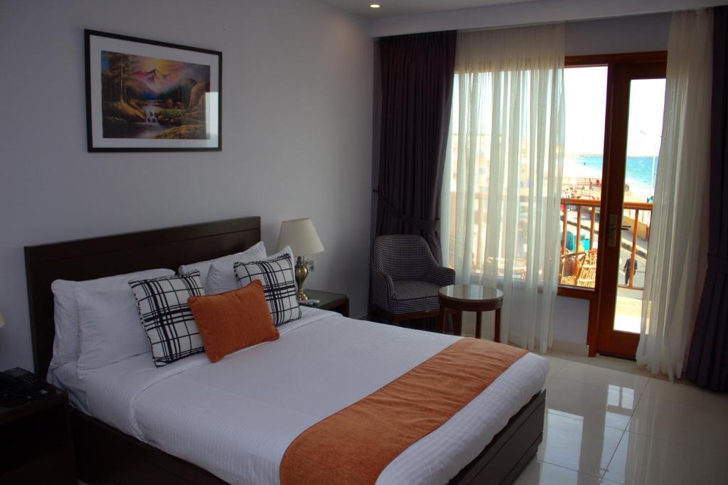 a hotel room with a bed and a balcony at Destination Beach Hotel by Dreamworld in Karachi