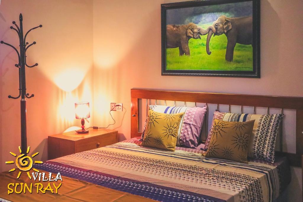 una camera con un letto con una foto di due elefanti di Villa Sun Ray a Tissamaharama