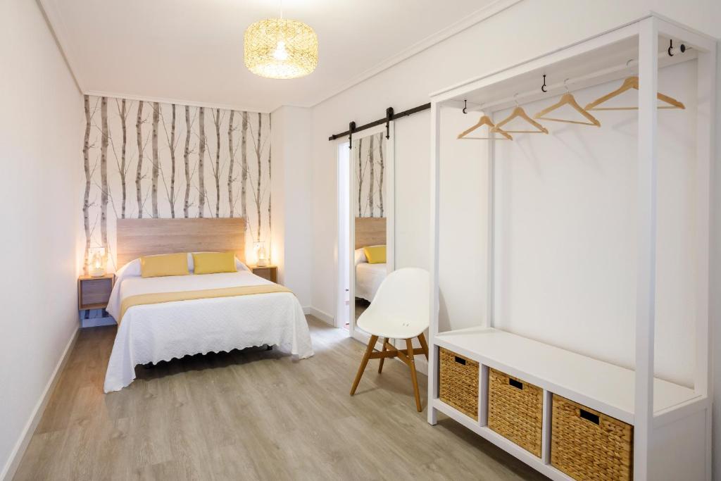 1 dormitorio blanco con 1 cama y 1 silla en Zaldivar etxea, en Leza
