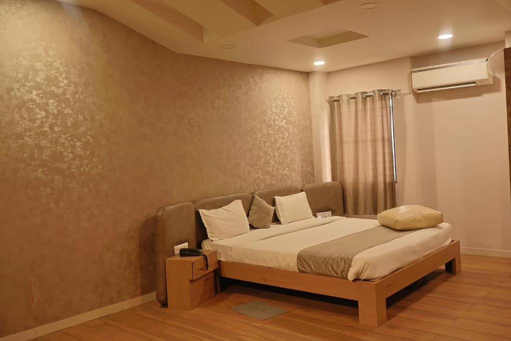a bedroom with a bed in a room at Hotel Shree Meghdootam in Bhopal