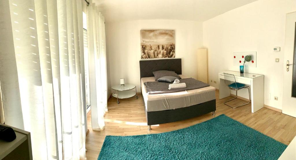 ブルクハウゼンにあるZV-Scholtz Burghausen Mozartstr, 15 AP-KLのベッドルーム1室(ベッド1台、青い敷物付きのテーブル付)