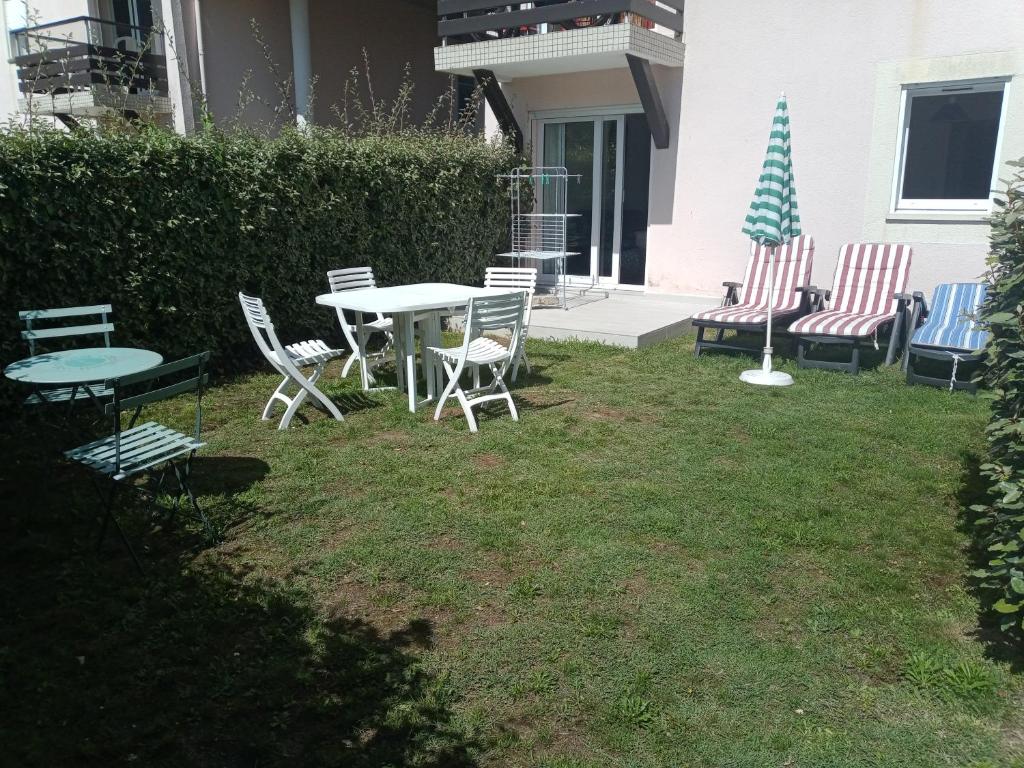 een patio met stoelen en een tafel en stoelen bij Appartement 2 pièces RDC jardin dans résidence avec piscine in Arzon