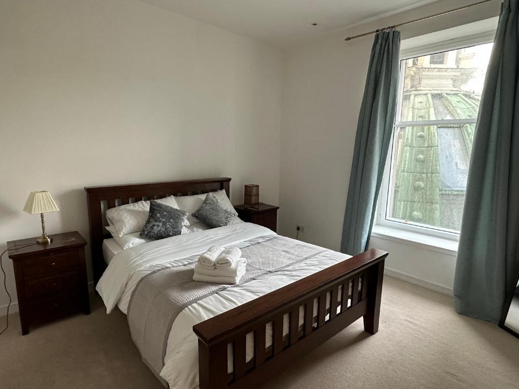 a bedroom with a large bed and a window at Comfy Two Bedroom Apartment Right In The City Centre in Glasgow